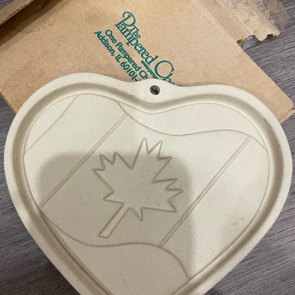 Pampered Chef Logo on Brown Background